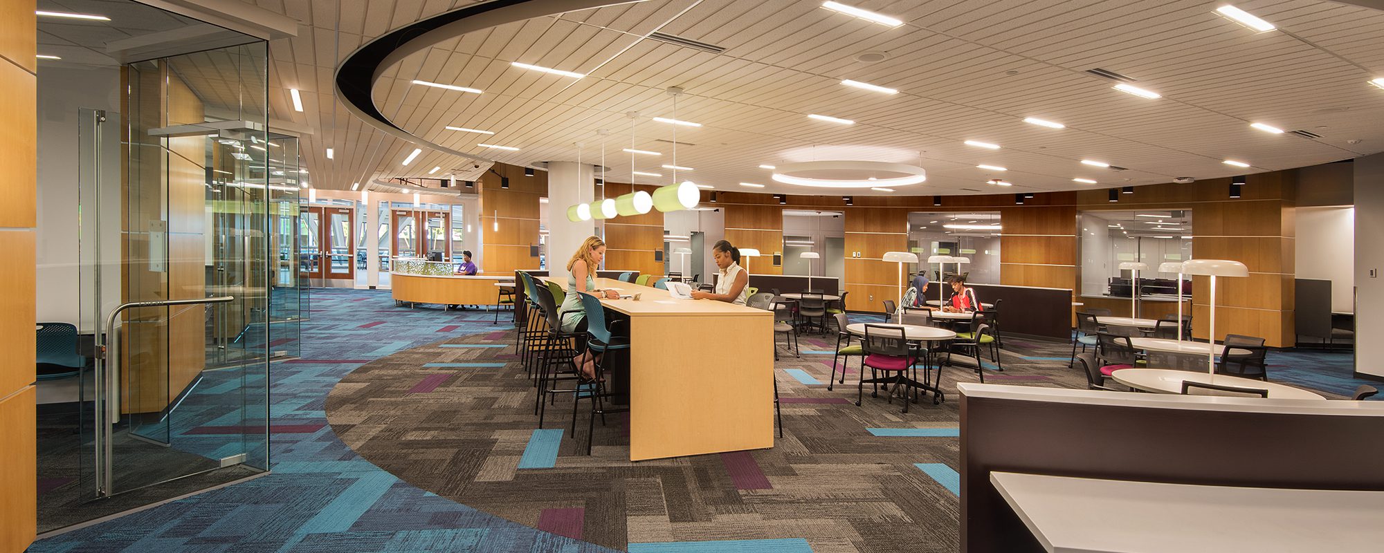 Students studying in school building with colorful interior and contemporary furnishings