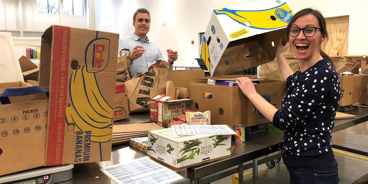 man and woman holding banana boxes
