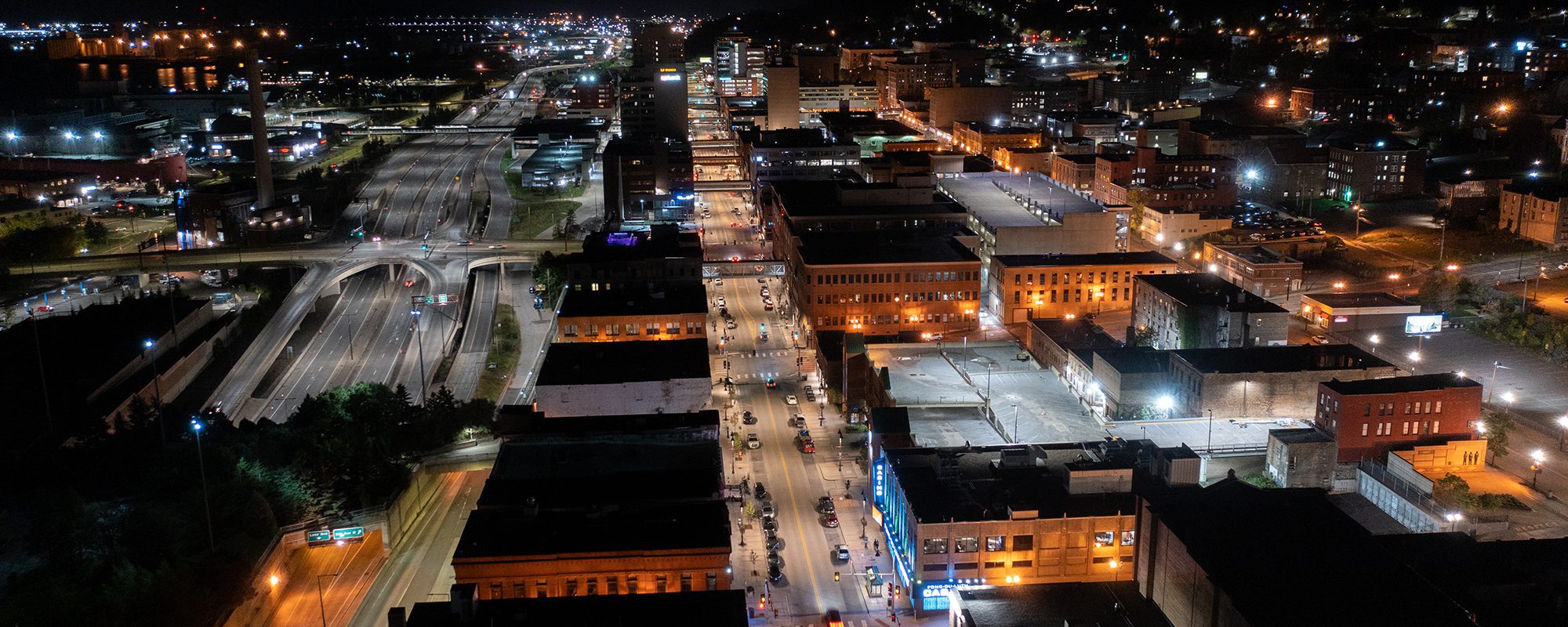 Aerial view of parallel roads and a highway in a city at night