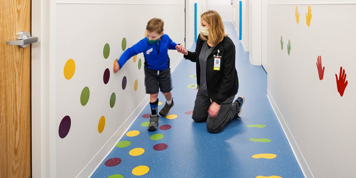 Child and nurse in colorful hallway