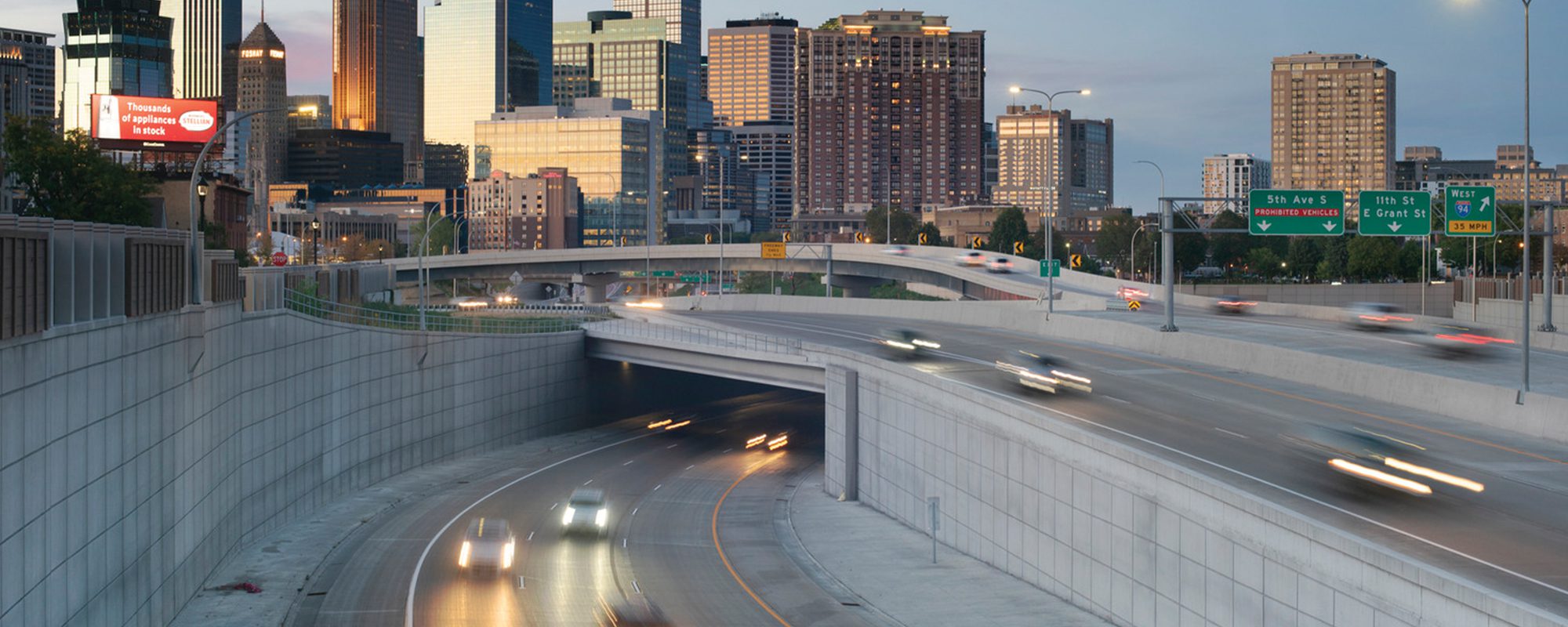 highway overpass with cars running below at night after completion of bridge design services