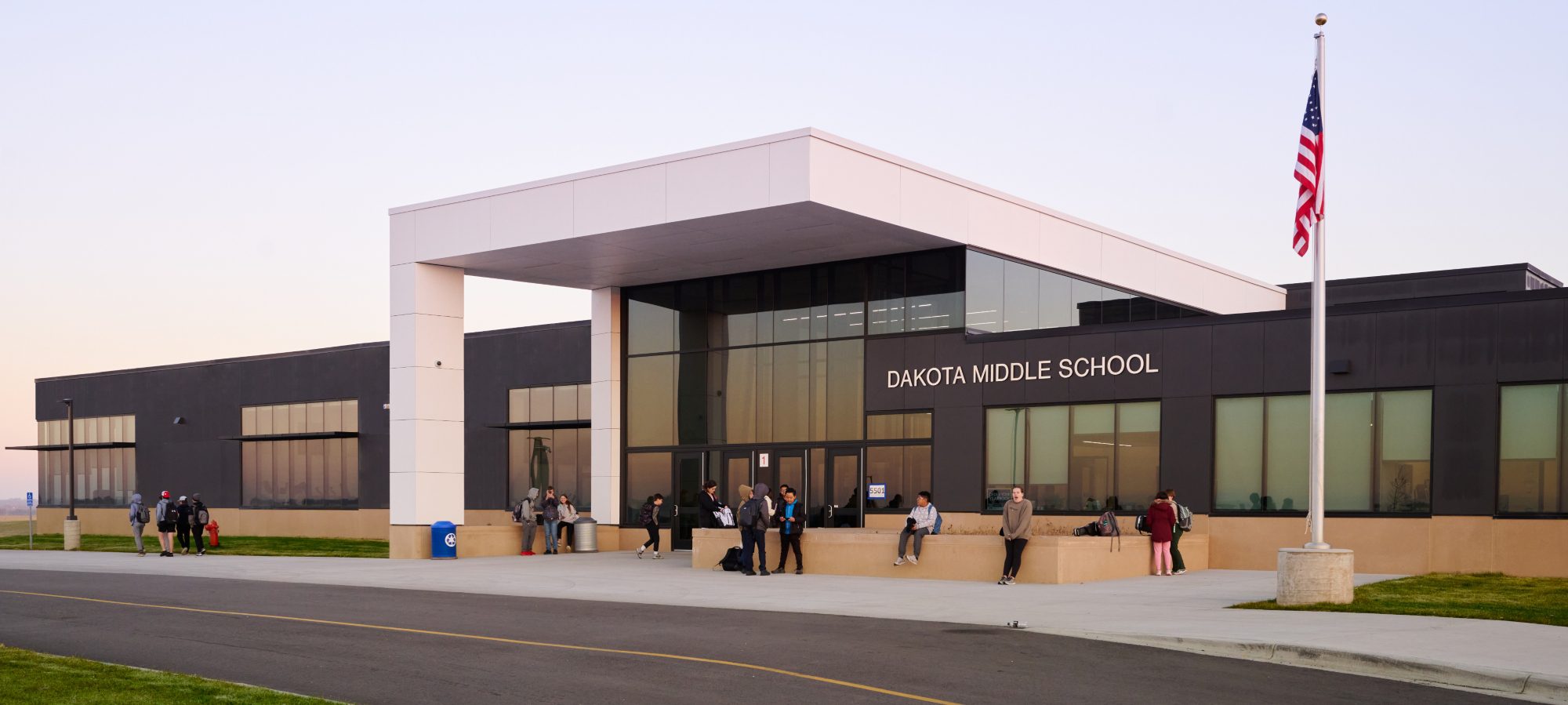 Exterior of school with contemporary design and students out front