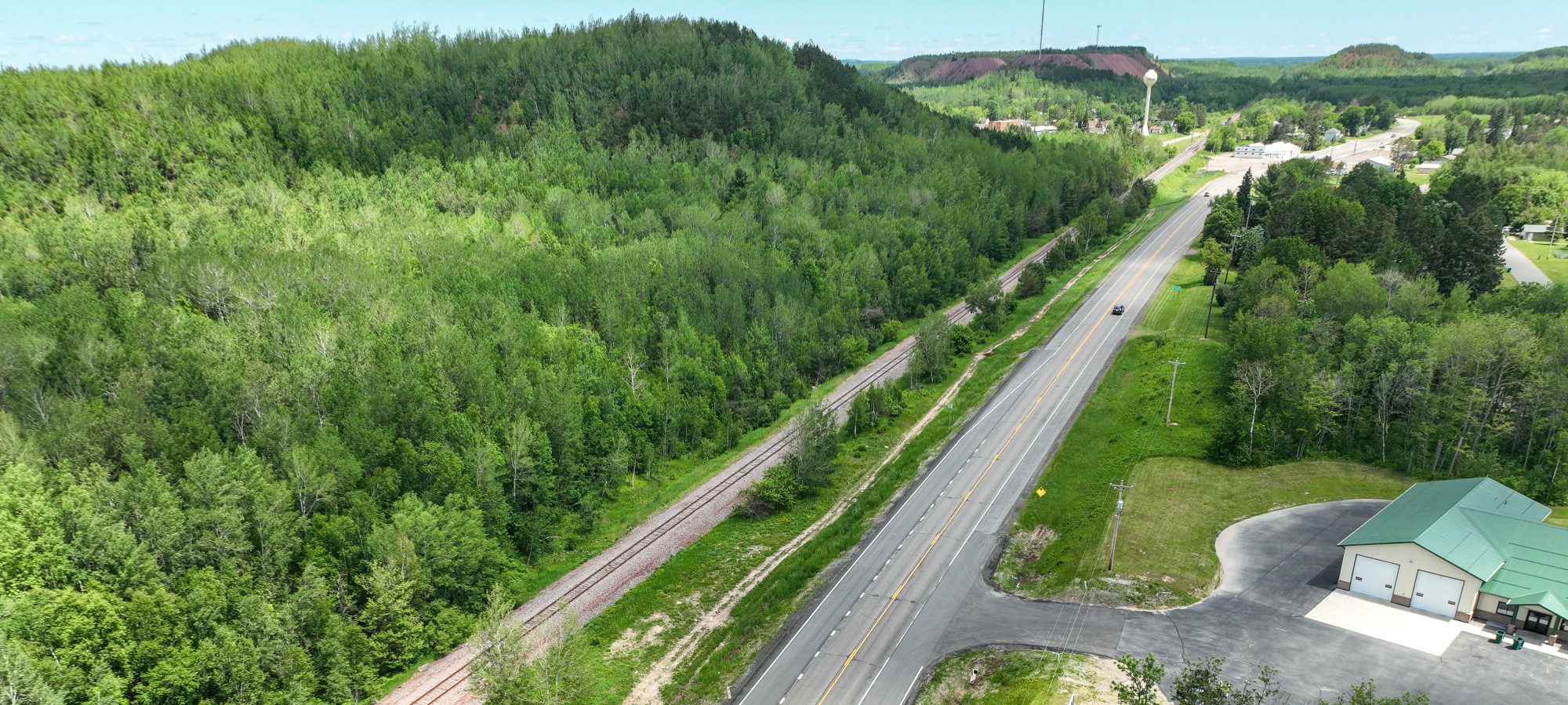 Aerial view of roadway through lush green forest