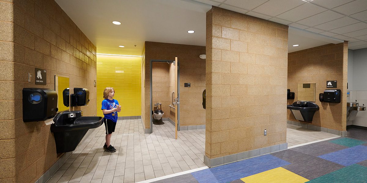 Student drying hands in bathroom