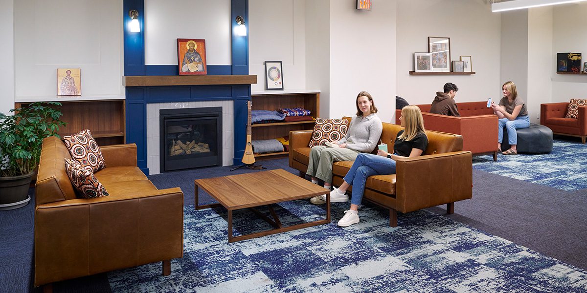 two ladies visiting in front of fireplace