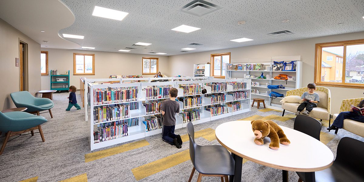 child looking at books on book shelf